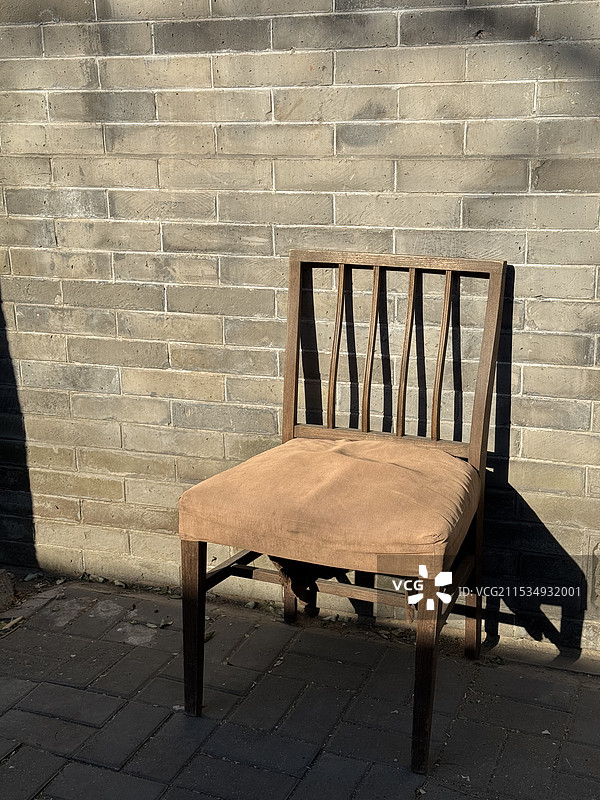 冬日暖阳中北京胡同里一把孤独的椅子图片素材