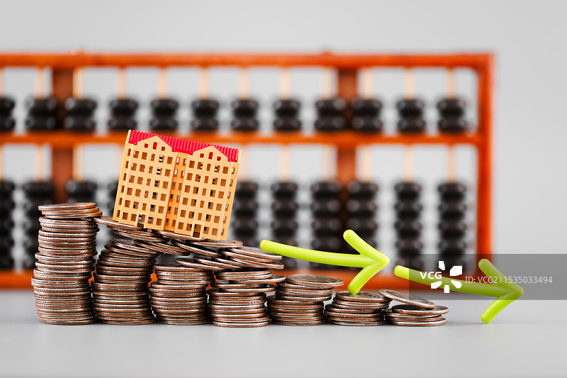 房子模型持续走低硬币上箭头和算盘图片素材