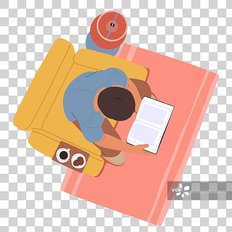 男人坐在黄色沙发上喝咖啡，专心阅读一本书图片素材