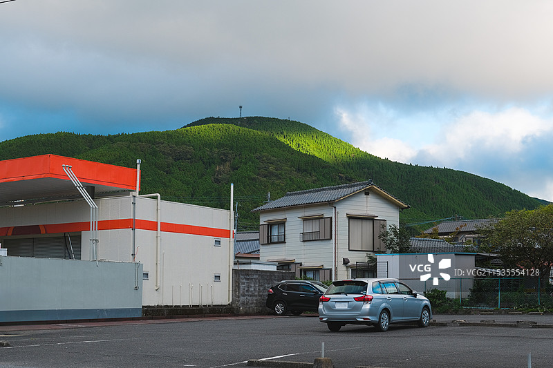 夏天的日本九州大分县由布院小镇山脚下的日式房屋加油站与停车场图片素材