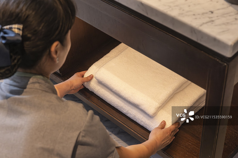 酒店客房服务员正在更换摆放浴巾毛巾，五星级豪华酒店客房保洁人员整理房间图片素材