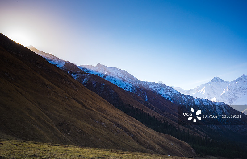 雪山清晨一缕阳光照在草地上图片素材