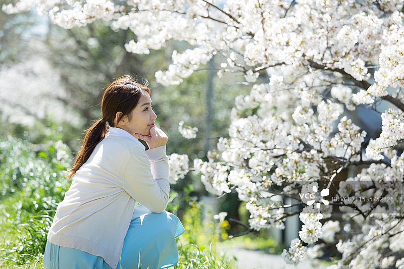 年轻女性在盛开的樱花下尽情享受图片素材