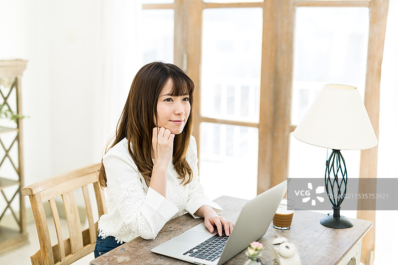 年轻女性在桌子上使用电脑图片素材