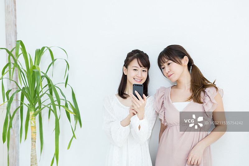 两名女性正在使用手机图片素材