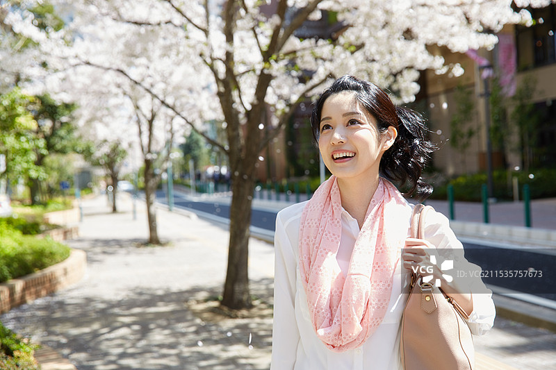女人在樱花树下放松图片素材