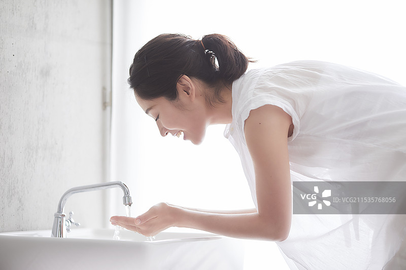 女人在洗脸盆里洗脸图片素材