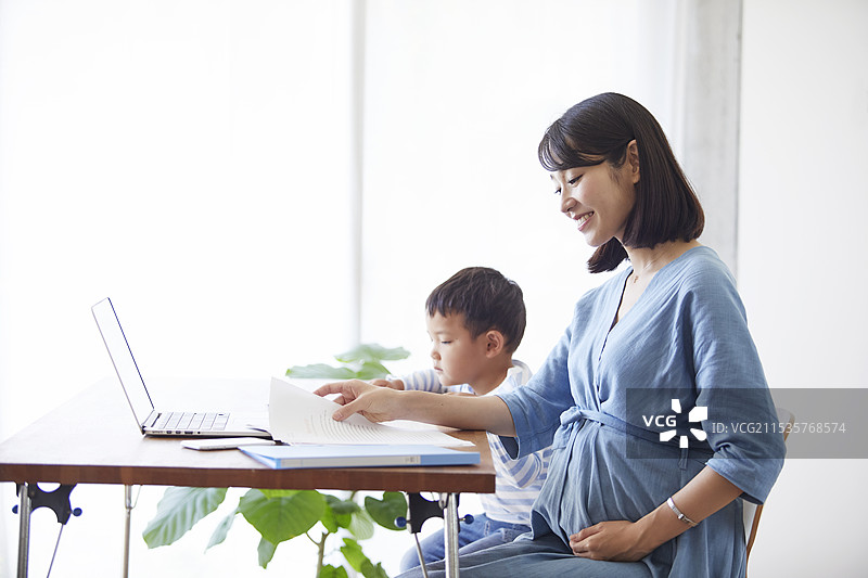 女性在工作，男孩在看平板设备图片素材