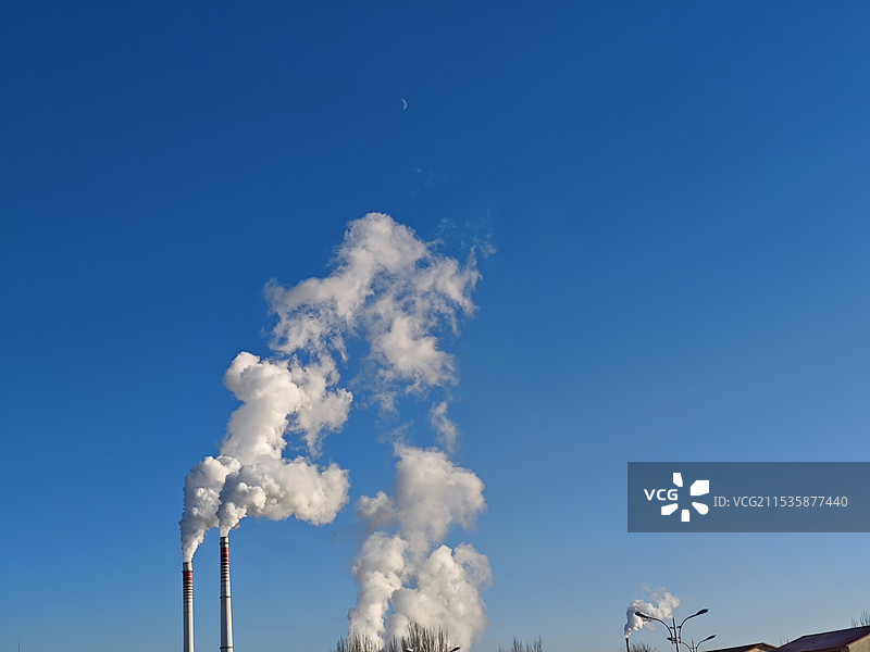 蓝天下烟囱的低角度视图图片素材