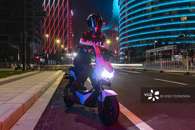 夜晚骑着电动车的年轻女孩图片素材