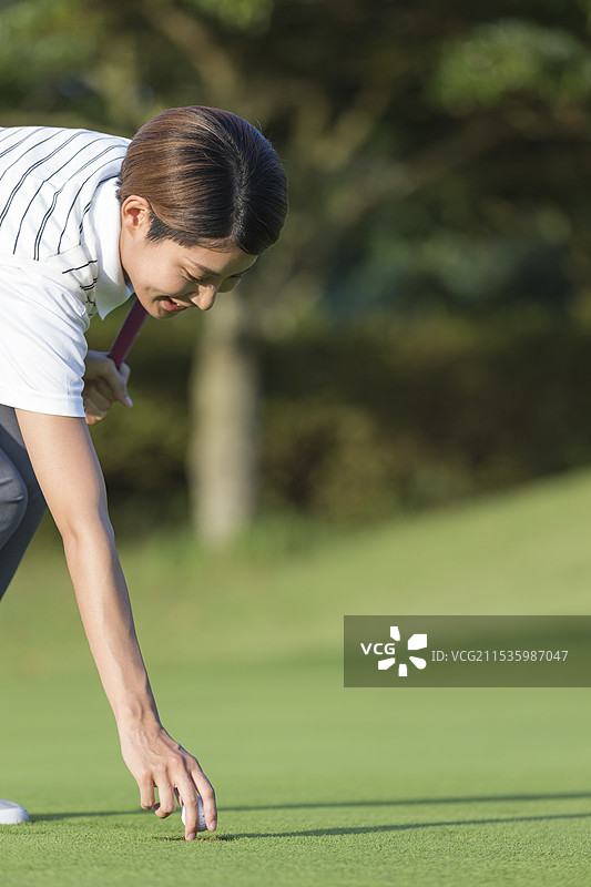 20多岁的女性在捡高尔夫球图片素材