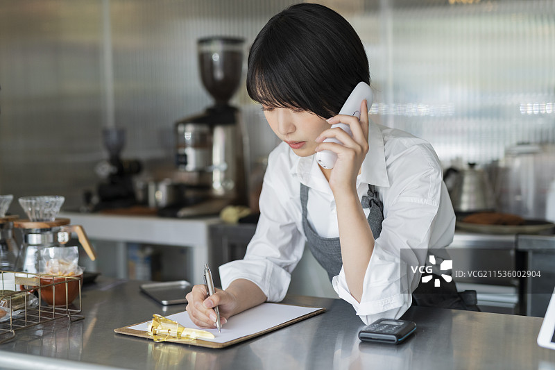 咖啡馆女员工正在打电话图片素材