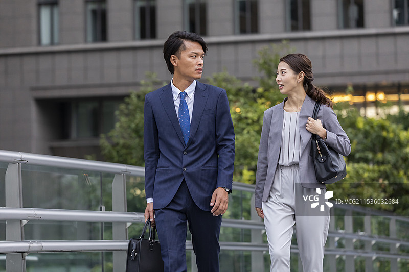 商人和女商人在办公大楼内走动图片素材