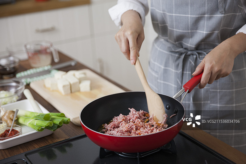 女人在煎炒剁碎的肉图片素材