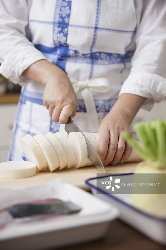 女人将萝卜切成圆片图片素材