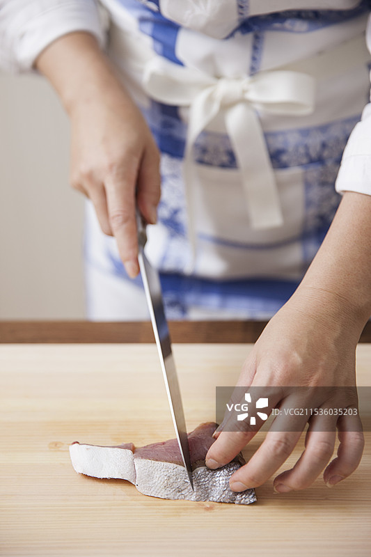 女人在切割黄尾鱼图片素材