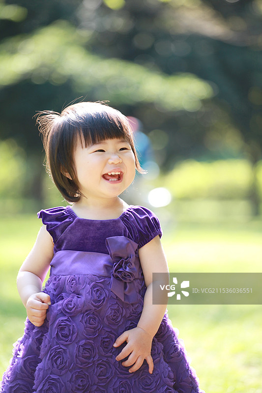 穿着裙子的宝宝在公园里玩耍图片素材