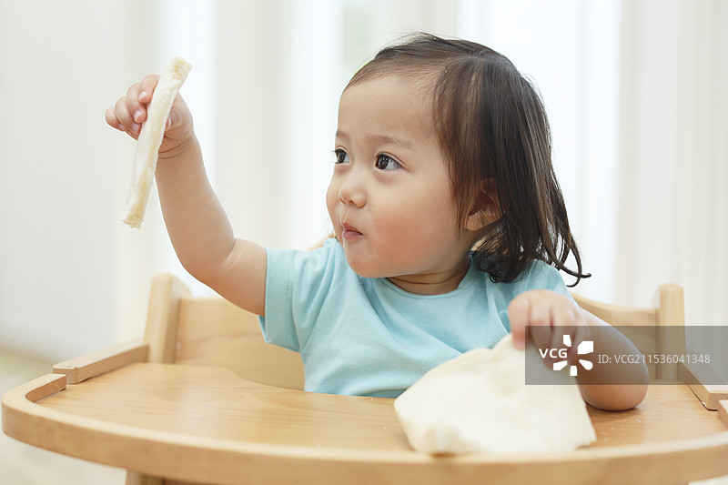 女孩在吃一条面包图片素材