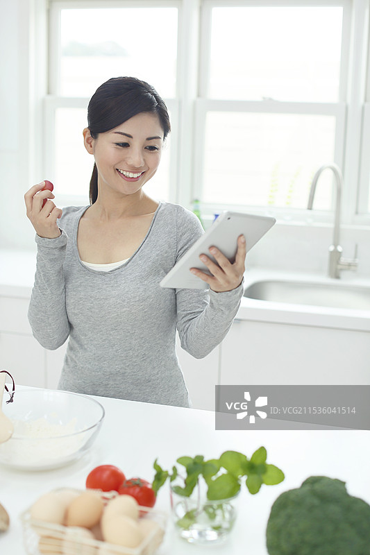 女人在厨房里查看平板电脑以搜索菜单图片素材
