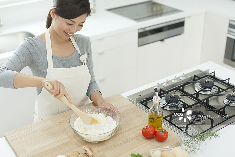 女人在明亮的厨房里烹饪图片素材