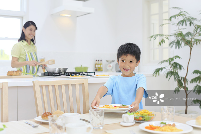 母亲和孩子在明亮的厨房里做早餐图片素材