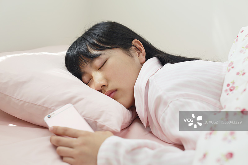女孩手里拿着手机睡觉图片素材