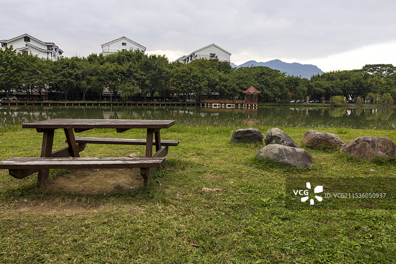 大学里的湖水与岸上绿地及木制长椅图片素材