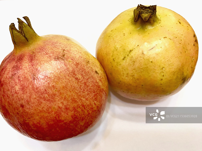 金秋时节石榴正当时-白色背景下的两个石榴的特写镜头图片素材