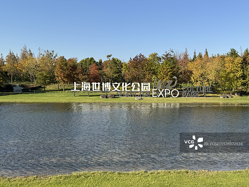 秋天上海世博文化公园入口标示牌与湖边的树木图片素材