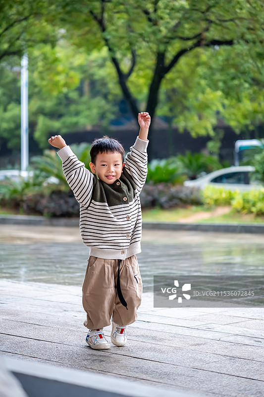 站在人行道上的可爱男孩，元气满满图片素材