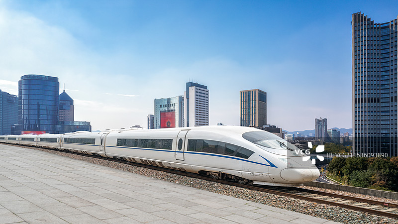 高速列车行驶在现代城市，背景是现代城市建筑景观天际线图片素材
