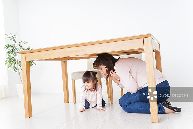 父母和孩子躲在桌子下避难图片素材