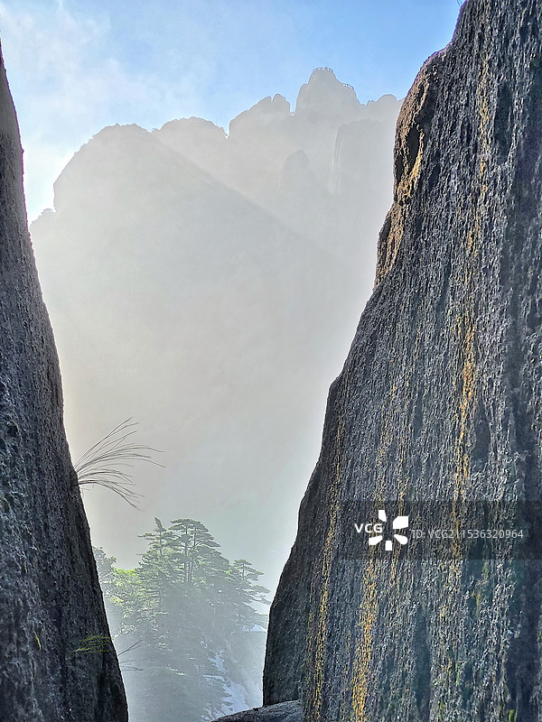 蓝天白云下安徽黄山云烟缭绕着的莲花峰顶剪影图片素材