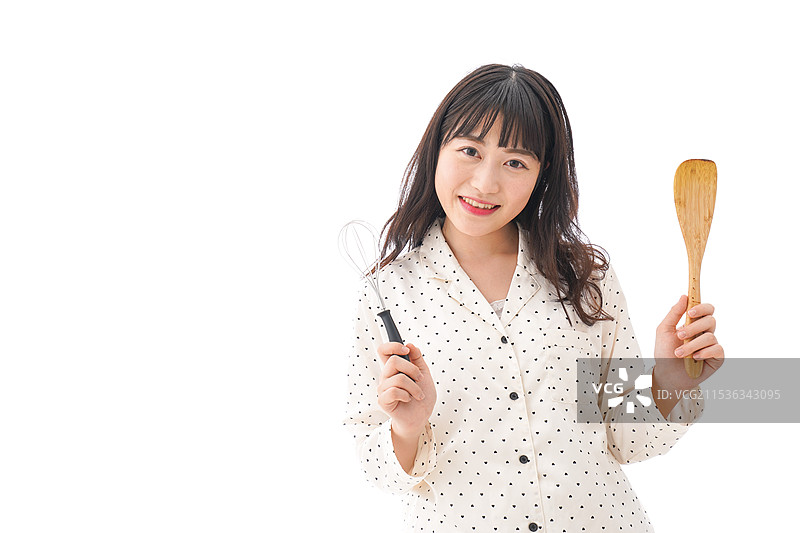 年轻女性穿着围裙在烹饪食物图片素材