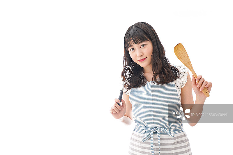 年轻女性穿着围裙在做饭图片素材