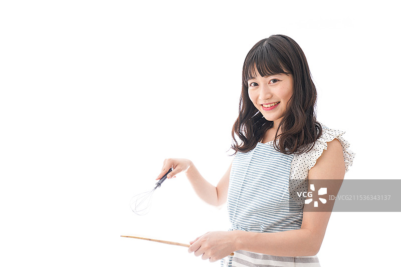 年轻女性穿着围裙在做饭图片素材