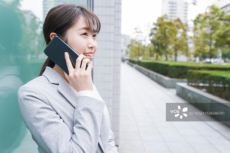 年轻女商人在办公大楼内打电话图片素材