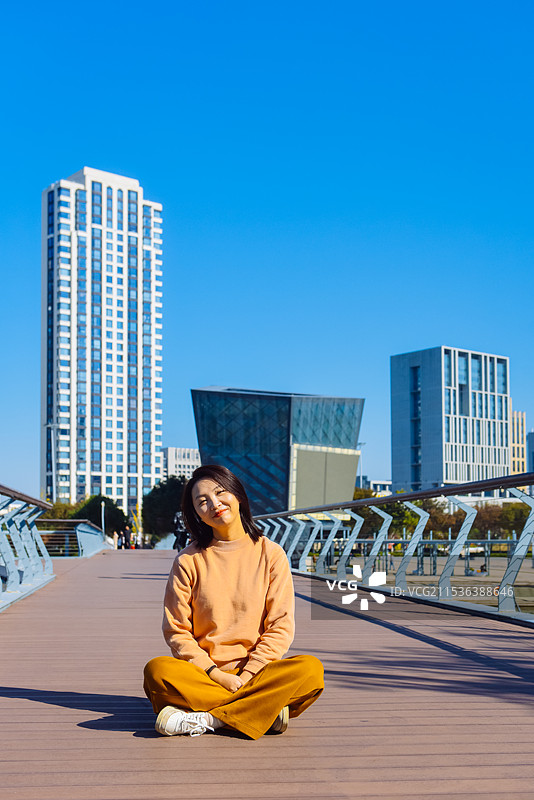 一位亚洲女性在宁波市鄞州公园星波桥享受美丽秋景图片素材