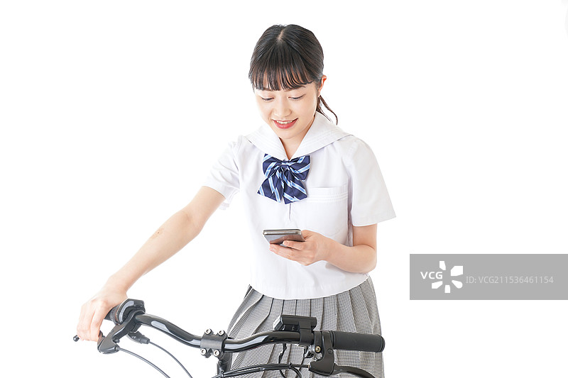 年轻学生骑自行车时使用智能手机图片素材