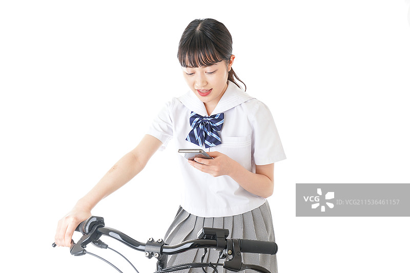 年轻学生骑自行车时使用智能手机图片素材