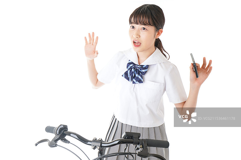 年轻学生骑自行车时使用智能手机图片素材