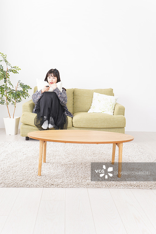 年轻女性在家看电视图片素材