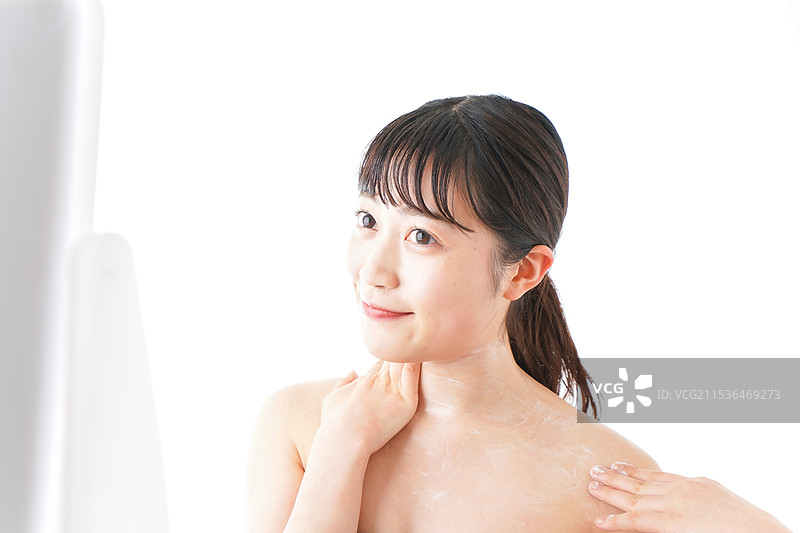 年轻女性在涂抹护肤霜图片素材