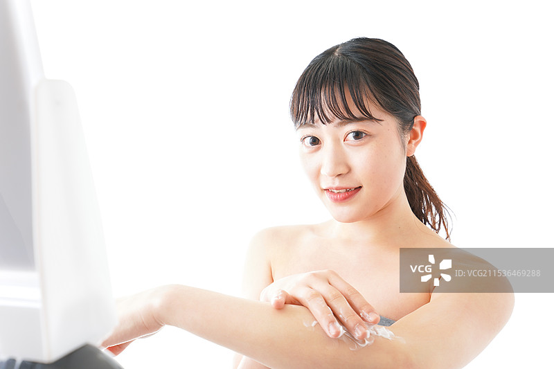 年轻女性在涂抹护肤霜图片素材