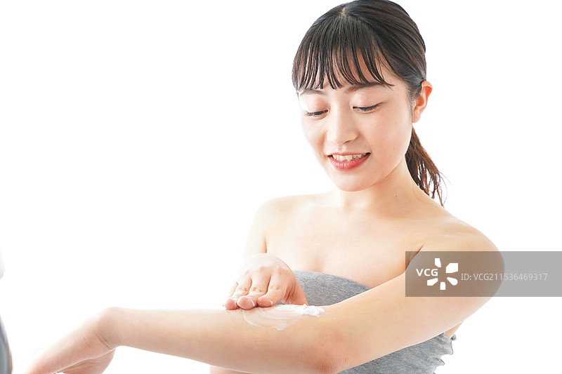 年轻女性在涂抹护肤霜图片素材