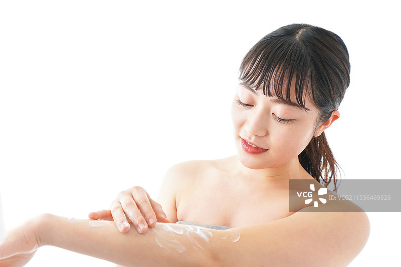 年轻女性在涂抹护肤霜图片素材