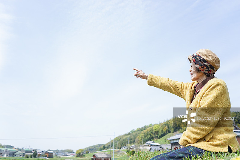 一位老年女性指着天空图片素材