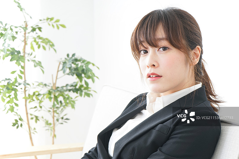 穿着西装的女商人在办公室里坐着图片素材