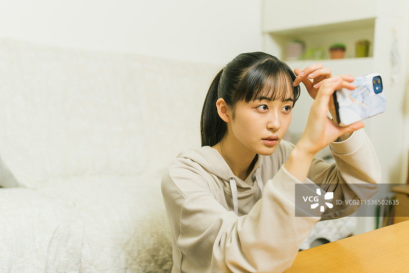 女孩在自拍中整理刘海图片素材