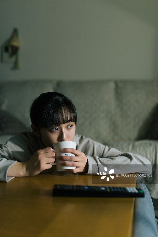 年轻女性在关灯的情况下看电视图片素材